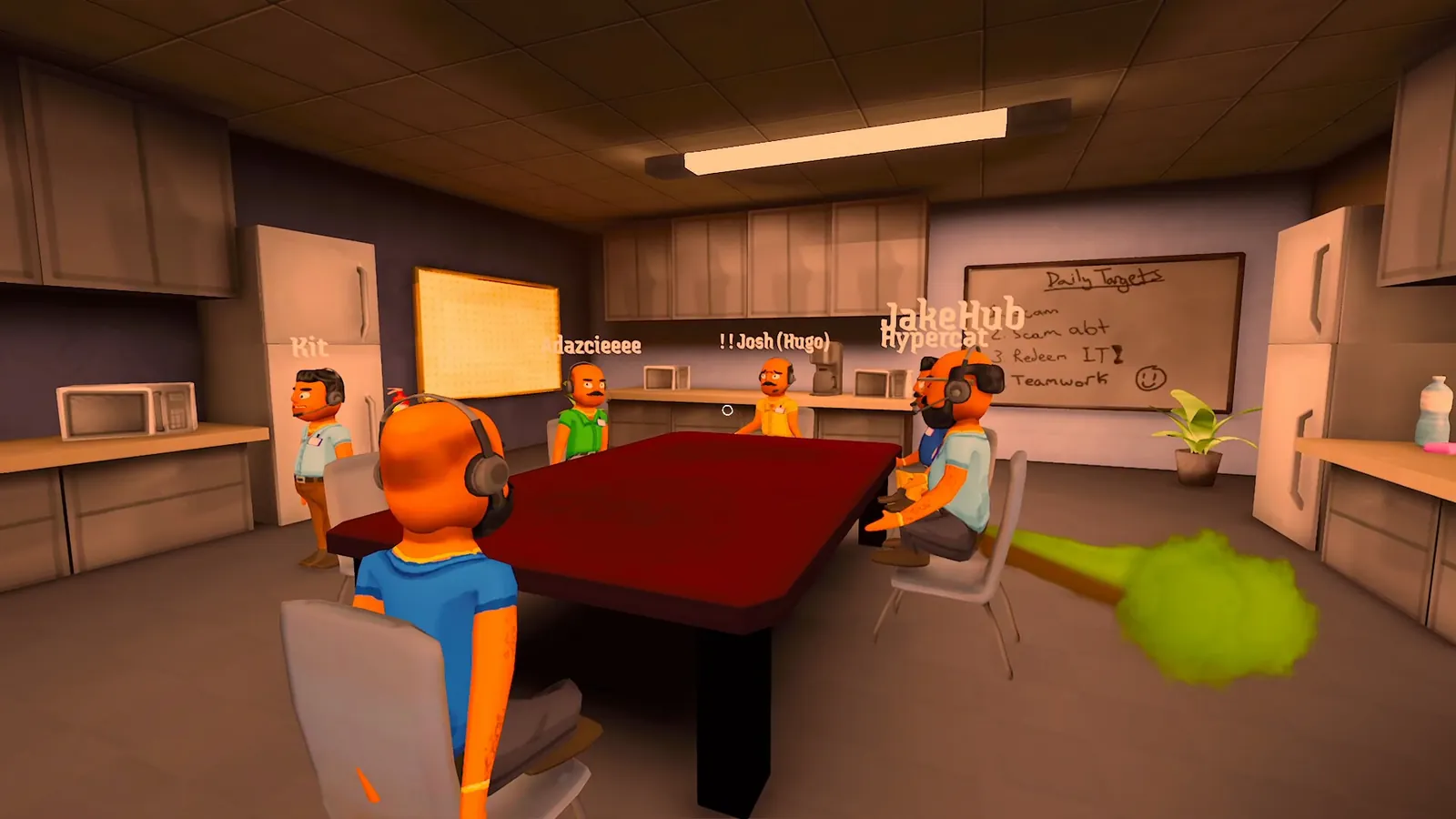 Players seated around a red table in the meeting room with a whiteboard behind them